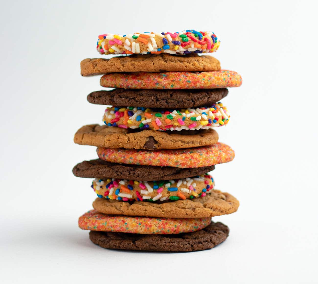 Picture of a dozen cookies including Birthday cake, Original chocolate chip, Sugar, Double fudge cookies alternately stacked